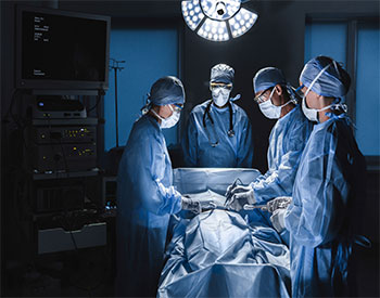 Diverse team of surgeons performing surgery on patient in hospital operating room. Urgent treatment, plastic surgery. Specialists saving patient`s life in operation theater.